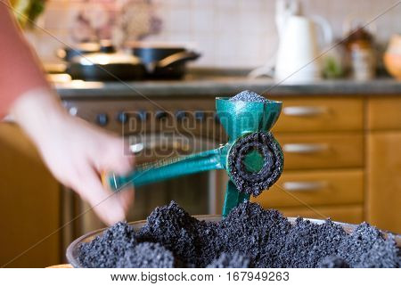 Chef grinds poppy with poppy seed grinder