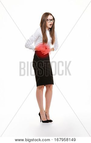 Full length portrait of a stressed businesswoman having stomach pain over white background