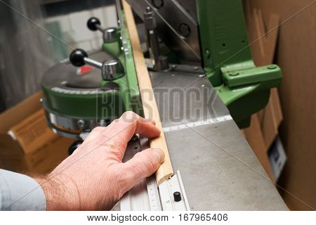 Craftsman working on frame in frameshop. Professional framer hand holding frame angle. Top view.