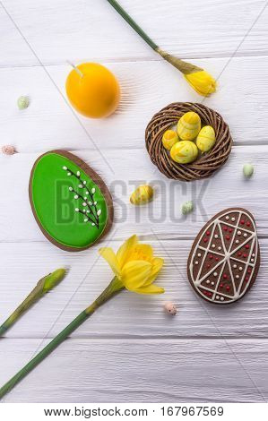 Happy holidays. Easter egg gingerbread and daffodils on white background