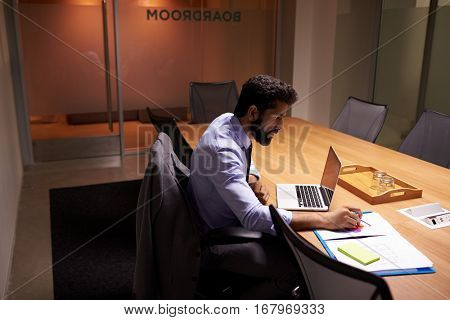 Hispanic businessman working late in office, elevated view