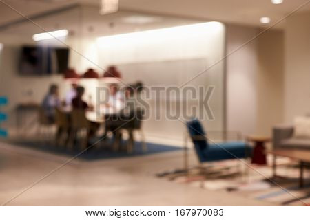 Team in a meeting cubicle at a big corporate business, defocussed
