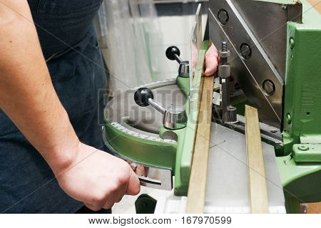 Craftsman working on frame in frameshop. Professional framer hand holding frame angle. Top view.