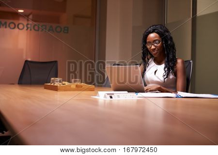 Young black businesswoman working late on laptop in office