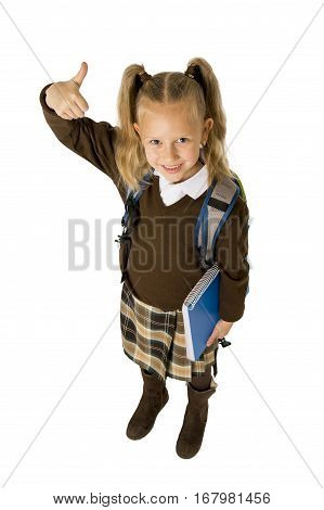 young beautiful blond schoolgirl with pigtails and school uniform carrying backpack and folder posing cheerful and happy isolated on white background in child education concept