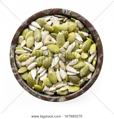 Sunflower and pumpkin seeds or pepitas in small stone bowl.  Top view, isolated with soft shadow.  Healthy eating.