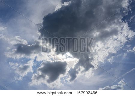 The sun is shining through the storm cloud in the sky