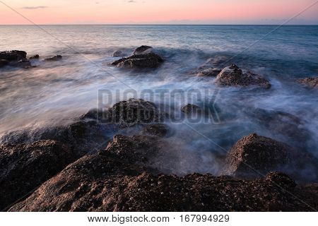 Waves and rocks shore long exposure photo