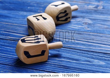 Dreidels for Hanukkah on blue wooden table, close up