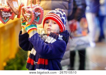 Little Cute Kid Boy Buying Sweets From A Cancy Stand On Christmas Market