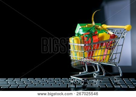 Ciber Monday Concept - Trolley Cart With Christmas Presents On Notebook, Isolated On White