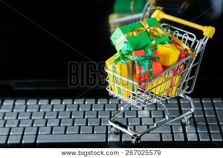 Ciber Monday Concept - Trolley Cart With Christmas Presents On Notebook, Isolated On White