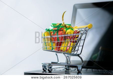 Ciber Monday Concept - Trolley Cart With Christmas Presents On Notebook, Isolated On White