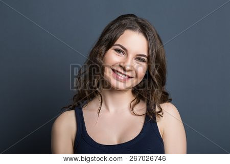Beautiful Young Girl On A Gray Background Smiling. Thoughtfully Smiling Young Beautiful Girl On A Gr