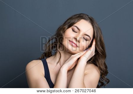 Beautiful Young Girl On A Gray Background Smiling. Thoughtfully Smiling Young Beautiful Girl On A Gr
