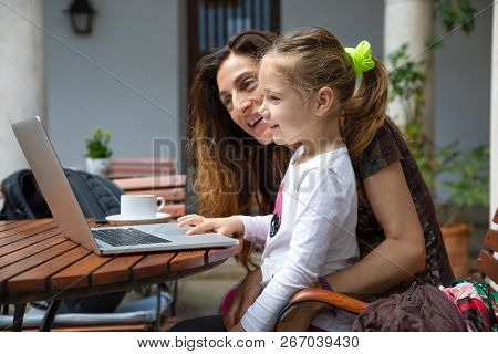 Little Girl And Mother Smiling Watching Laptop