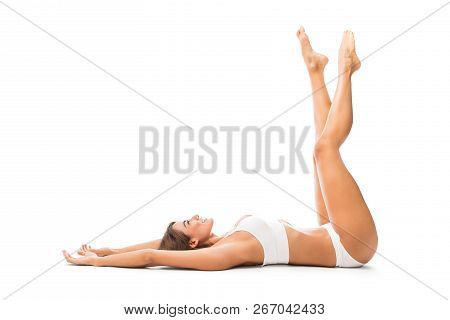 Full Length Of Carefree Woman With Arms And Legs Up Lying In Studio