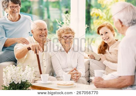 Happy Elderly People Drinking Tea In The Common Room Of Nursing House