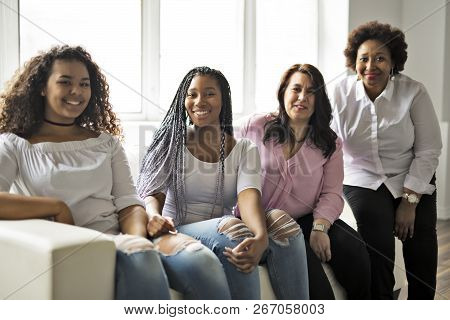Two Family Friends Sitting On Sofa Together