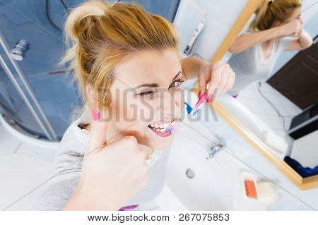 Woman Brushing Cleaning Teeth Closeup. Funny Blonde Girl With Toothbrush In Bathroom Making Thumb Up