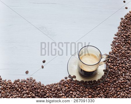 Coffee Beans With A Cup Of Coffee On A Wooden Table