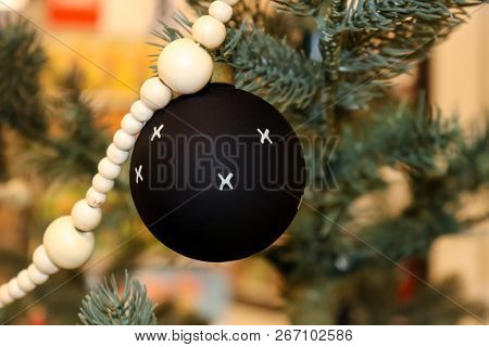 Black Christmas Ball With White Xs With Other Ornaments On Modern Decorated Christmas Tree