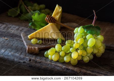 Slate Board With Various Cheese And A Glass Of Red Rose Wine. Gouda, Masdaam, Cheddar And Grapes On 