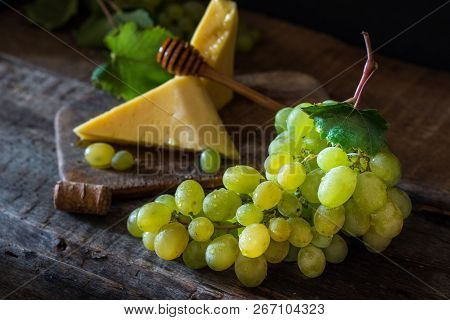 Slate Board With Various Cheese And A Glass Of Red Rose Wine. Gouda, Masdaam, Cheddar And Grapes On 