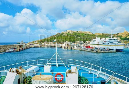 The Ro-ro Ferry Floats To Its Terminal In Mgarr Harbour Of Ghajnsielem, Gozo Island, Malta.