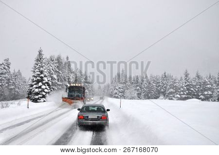 Difficult Traffic After Snowing. The Snow Cleaner Operatively Cleans The Snow-covered Mountain Road.