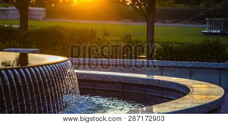 Outdoor Fountain With Reflective Water At Sunset