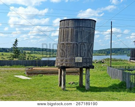 Nizhnyaya Sinyachikha,russia- Aug 05,2018: Large Wooden Barrel For Water Against Fire Near Fire Towe