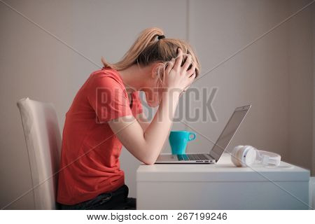 Young blonde woman trying to study