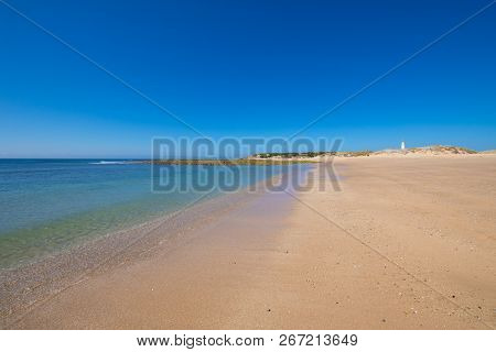 Lonely Cala Marisucia And Trafalgar Lighthouse From Seashore