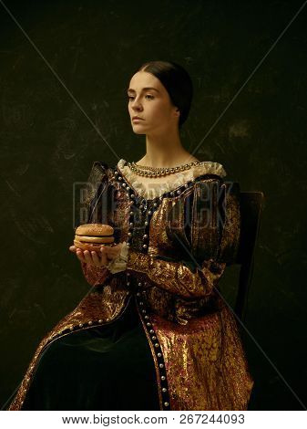 Portrait Of A Girl Wearing A Princess Or Countess Dress Over Dark Studio. Portrait With Burger
