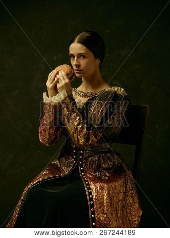 Portrait Of A Girl Wearing A Princess Or Countess Dress Over Dark Studio. Portrait With Burger