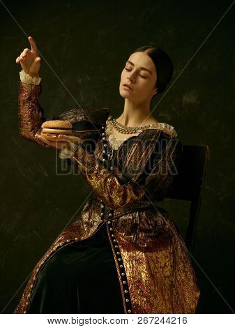 Portrait Of A Girl Wearing A Princess Or Countess Dress Over Dark Studio. Portrait With Burger