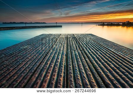 Architecture Built Jetty On The Water With Perspective And Calm Water At Sunny Sunset
