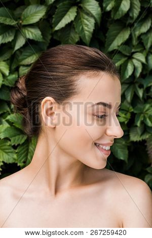 Smiling Young Woman With Green Leaves At Background