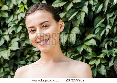 Smiling Young Woman With Green Leaves At Background