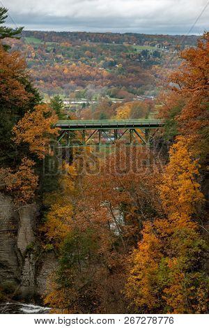 Pedestrian Suspension Bridge Over Triphammer Falls, Ithaca, New York. Waterfall In The Middle Of Cor