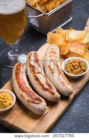 Grilled german sausages with mustard and fried potato chips