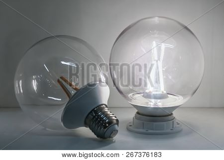 A Led Glass Transparent Lamp Classic Ball Form Is On And A Led Glass Transparent Lamp With An Orange