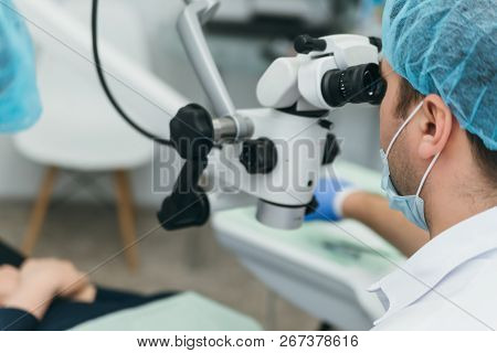 Doctor Used Microscope. Dentist Is Treating Patient In Modern Dental Office. Operation Is Carried Ou