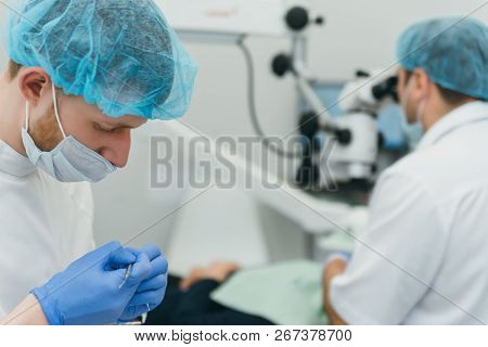 Doctor Used Microscope. Dentist Is Treating Patient In Modern Dental Office. Operation Is Carried Ou