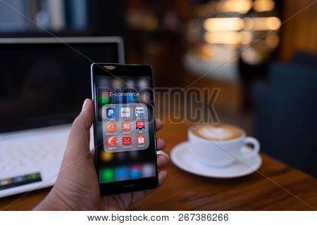 Chiang Mai, Thailand - May 19,2018: Man Holding Huawei With Icons Of E-commerce And Online Shopping 