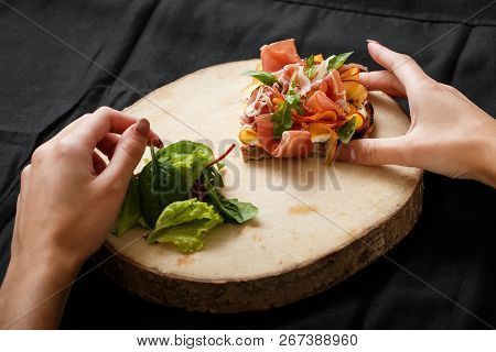 Close Up Sandwich With Jamon And Salad On Board. Womans Hand Holding Folk And Knife. Sandwich With J