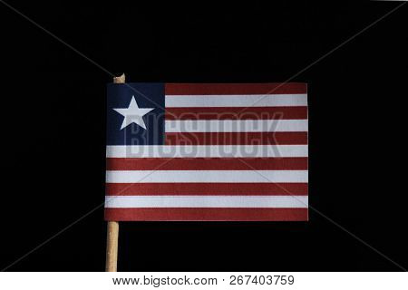 A Official Flag Of Liberia On Toothpick On Black Background. Consists Of Eleven Horizontal Stripes A