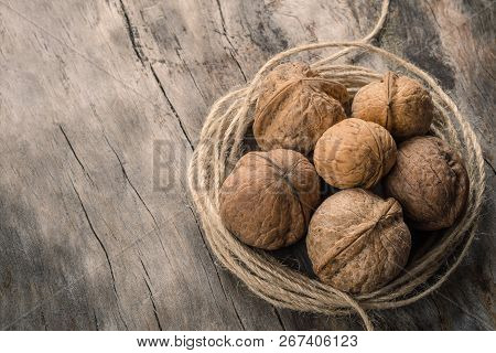 Walnuts Kernels With Twine On Wooden Log.