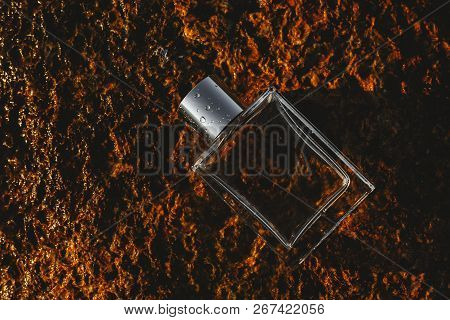 Male Bottle Perfume Against A Yellow Stone